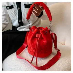 Detail of red plush bucket bag with THE BUCKET embossed lettering and drawstring