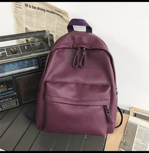 Close-up of deep purple lychee textured PU leather backpack with vintage radio background
