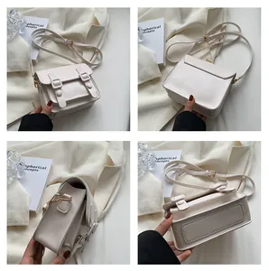 Detailoverzicht van de crème vintage crossbodytas met stiksels en goudbeslag