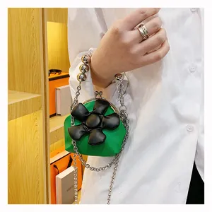 Detail of green mini leather bag with 3D black flower and silver beaded handle