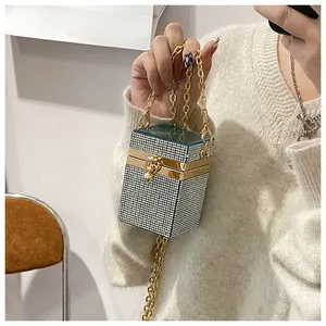 Détail du sac pochette strass en cube avec couvercle cyan et bandoulière dorée