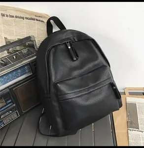 Close-up of black PU leather backpack with lychee texture and vintage radio background