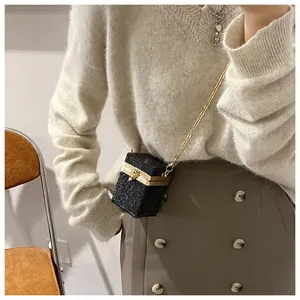 Gros plan d'un mini sac carré noir scintillant avec chaîne dorée sur un mannequin