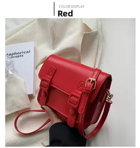 Detailopname van een stijlvolle rode crossbodytas met gouden hardware en vintage ontwerp