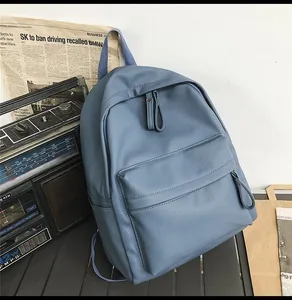 Detail view of smog blue lychee grain PU leather backpack with minimalist zipper pocket