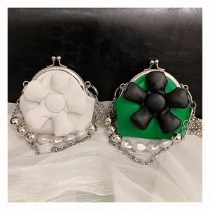 Close-up of mini crossbody bags with 3D leather flowers and pearl metal chains