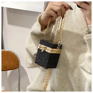 Détail d'une pochette de soirée noire ornée de strass brillants et d'une chaîne dorée