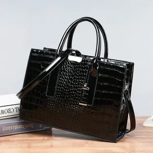 Glossy black crocodile pattern handbag with top handles and adjustable shoulder strap