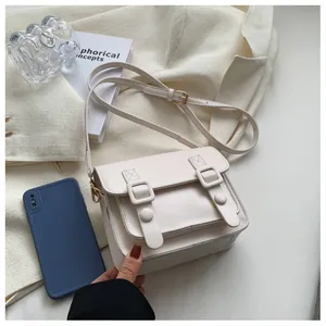 Detailweergave van de witte retro crossbodytas naast een smartphone voor de afmeting
