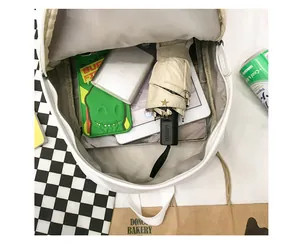 Internal view of a minimalist white school backpack showing spacious main compartment with layers