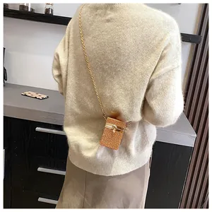 Détail d'un mini sac bandoulière orné de strass champagne scintillants et chaîne dorée