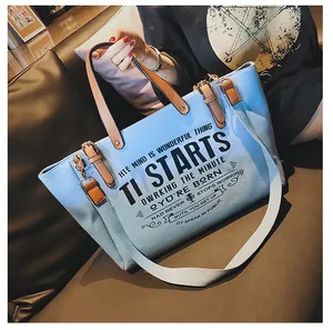 Hellblaue Canvas-Tragetasche mit braunen Ledergriffen und verstellbarem Schultergurt