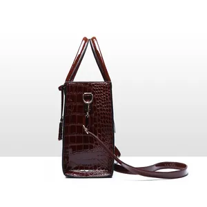 Side view of elegant brown crocodile pattern handbag with glossy finish and shoulder strap