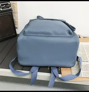 Detailed bottom view of blue PU leather backpack with lychee grain and adjustable strap