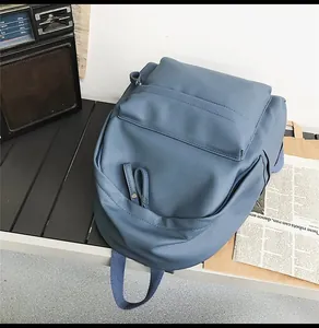 Close-up of blue lychee-grain PU backpack on a vintage bench with a retro radio