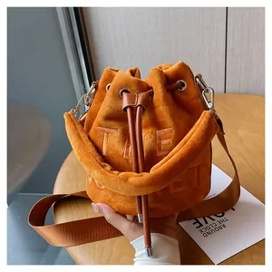 Close-up of orange-brown plush bucket bag featuring drawstring and embossed texture