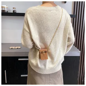 Mini sac bandoulière à strass avec chaîne dorée porté par un mannequin sur l'épaule