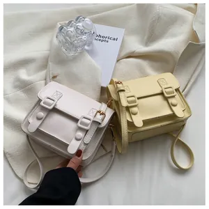 Minimalistische crossbodytassen in crème en zachtgeel op een decoratieve achtergrond