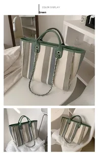 Detail of green striped canvas tote bag with woven texture and leather chain strap