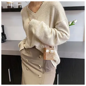 Détail d'un mini sac à chaîne doré étincelant avec strass porté en bandoulière tendance