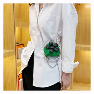 Mini green crossbody bag with 3D flower, silver chain and pearl accents on model