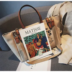 Detail einer cremefarbenen Canvas-Tasche mit braunen Ledergriffen auf grauem Sofa