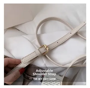 Close-up of adjustable beige leather shoulder strap with premium gold metal buckle detail