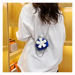 Detailed view of mini blue flower cross-body bag with pearl chain strap and metal clasp