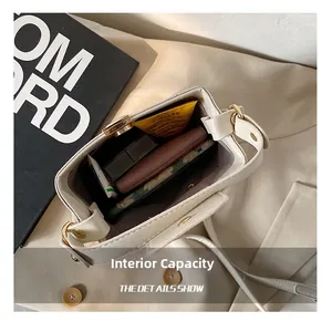 Macro shot of internal capacity showing essentials in cream crossbody bucket bag
