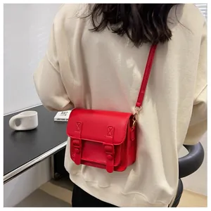 Achteraanzicht van een rode mini crossbody tas met dubbele riemen en goudkleurige haken