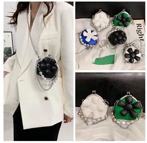 Detailed view of mini floral crossbody bag featuring pearl chain and clasp closure