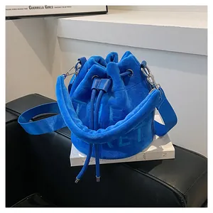 Detail of Klein blue velvet bucket bag with embossed The Secret text and drawstring closure