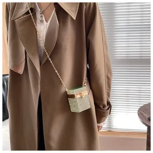 Vue détaillée du mini sac boîte en strass verts avec bandoulière chaîne dorée