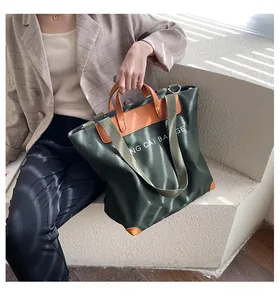 Detail of army green canvas tote bag with leather straps and white letter printing