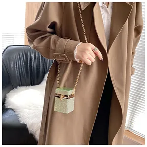 Détail d'un mini sac vert en strass avec boucle tête de léopard dorée et bandoulière chaîne