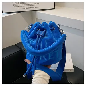Detail view of the plush blue velvet bucket bag featuring embossed THE BUCKET text