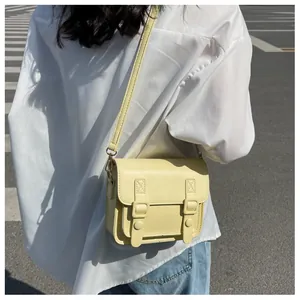 Detail van lichtgele Cambridge crossbodytas op model met casual outfit gedragen