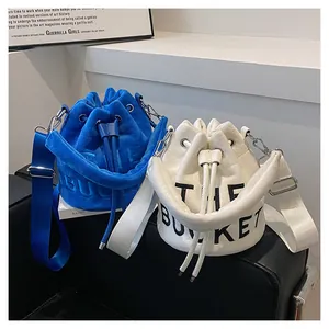 Detail of plush bucket bags in blue and white with THE BUCKET letter embossing