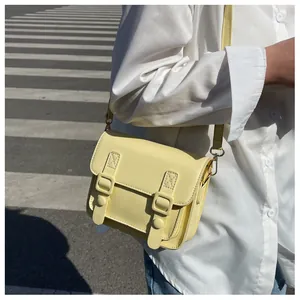 Gedetailleerde weergave van gele PU-leren Cambridge crossbody tas gedragen door een model