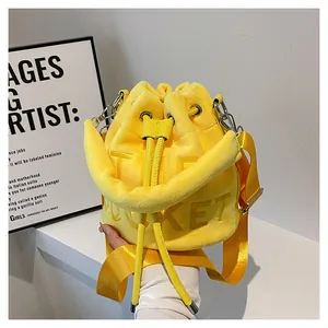 Detail of yellow plush bucket bag with THE BUCKET lettering and drawstring closure
