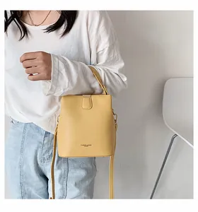 Detail of yellow PU leather bucket bag featuring magnetic closure and a sturdy top handle