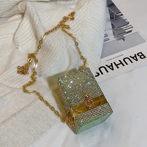 Mini pochette étincelante en strass argentés avec chaîne dorée sur fond en maille douce