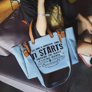 Große blaue Canvas-Tasche mit braunen Lederriemen und breitem Schultergurt