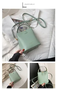 Detail view of the green bucket bag showing smooth PU leather and golden hardware