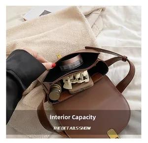 Internal capacity of the brown PU leather saddle bag showing phone and cosmetics