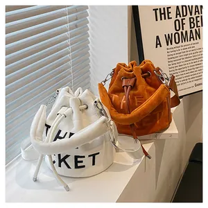 Detail of plush bucket bags in white and orange with drawstring closure and silver hardware