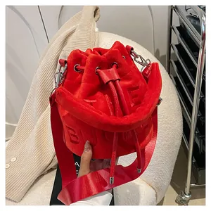 Detail of red plush bucket bag with embossed The Bucket lettering and silver hardware
