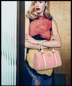 Detail of pink Boston handbag with geometric bone pattern and round gold metal logo