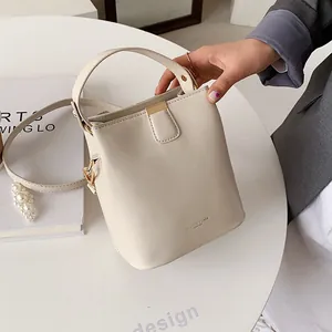 Creamy white leather bucket bag with gold hardware and strap for women’s fashion