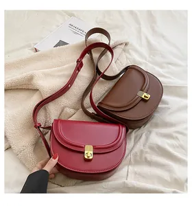 Close-up of vintage PU leather saddle bags with gold buckles on a cozy blanket